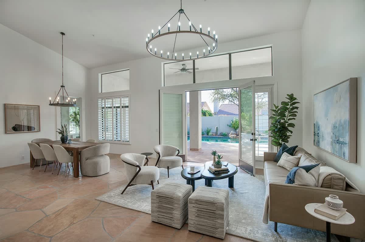 Formal living area with modern seating and a large open floor space connected to the formal dining area for 7 and bar area. Easy access to the private backyard.