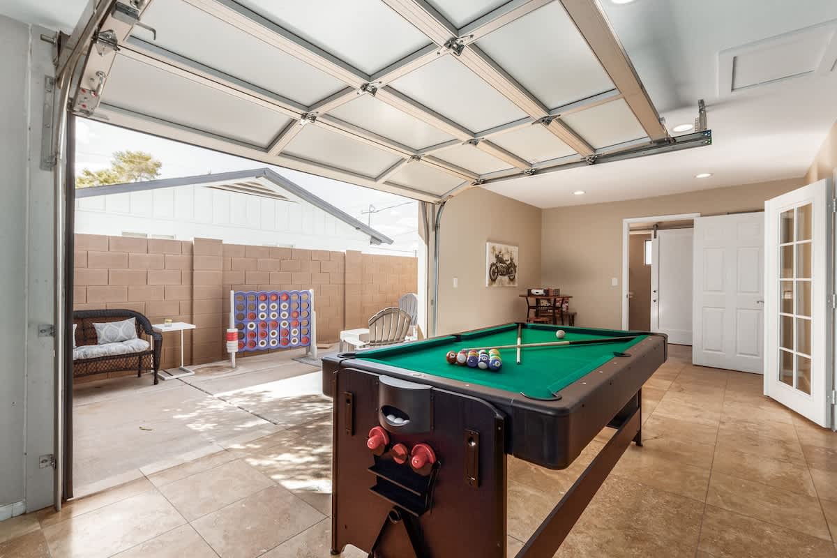 Game Room with board games, TV, multi-purpose game table for ping pong, air hockey, and pool, and access to the backyard.