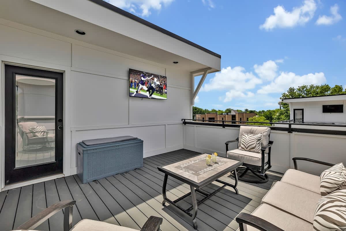 4th Floor: Private rooftop patio featuring outdoor furnishings for lounging and a Smart TV for entertainment surrounded by beautiful neighborhood views.