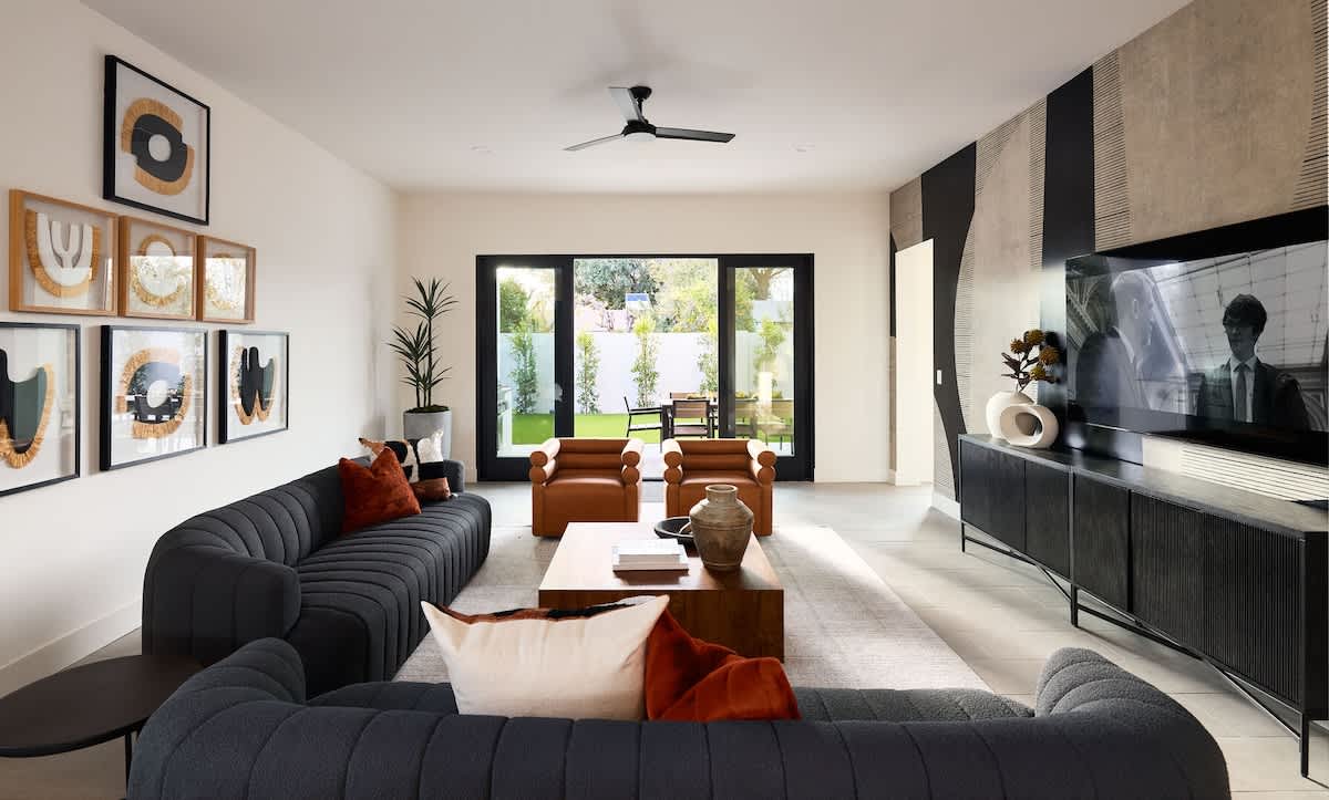 (1st Floor) Open floor plan main living area with designer decor, smart TV, comfortable seating, and access to the backyard.