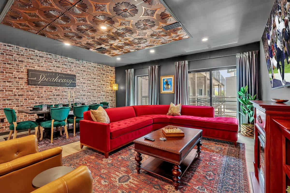 Open-floor living space featuring a smart flat-screen TV and designer furnishings. This inviting area effortlessly connects the dining space with the well-appointed kitchen.