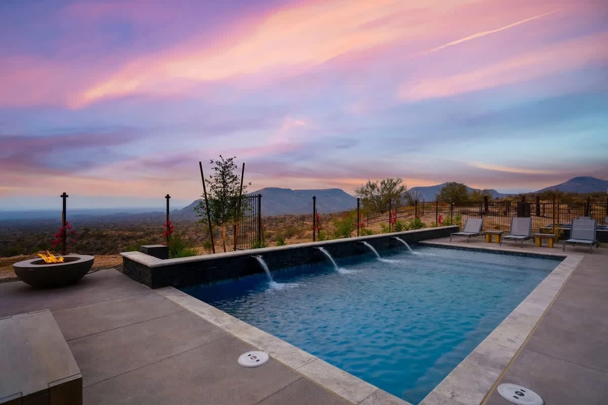 Estate 2: Stunning private oasis featuring a sparkling blue pool with sun loungers, a patio with a BBQ grill, outdoor furnishings for lounging and dining, and a fire pit surrounded by unparalleled des