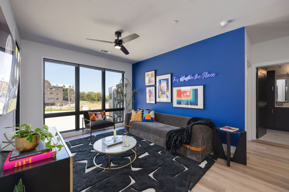 Bright open concept living area with floor to ceiling windows providing panoramic views of Midtown! Features designer furniture and smart TV!