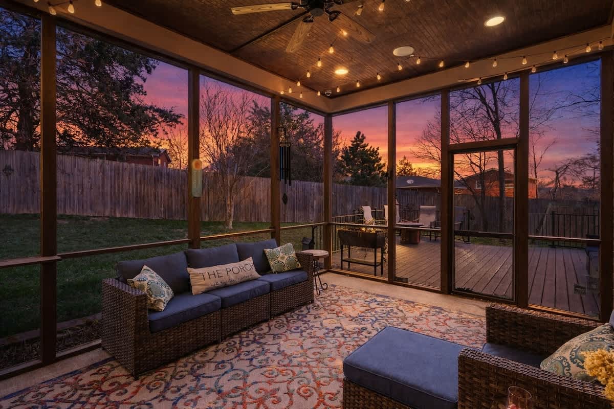 Private backyard featuring a covered patio with outdoor seating, a spacious deck with additional seating, a fire pit, BBQ grill, and a large open yard.