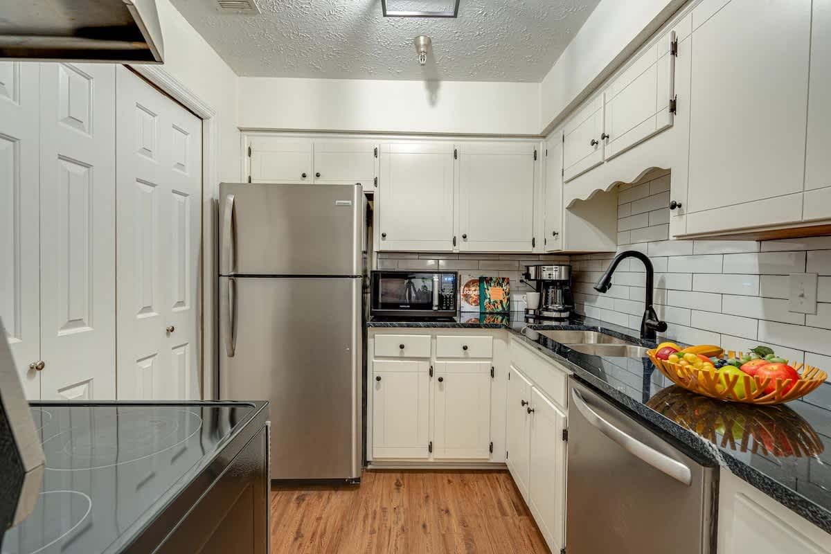 Full kitchen stocked with basic cooking essentials and stainless steel appliances.