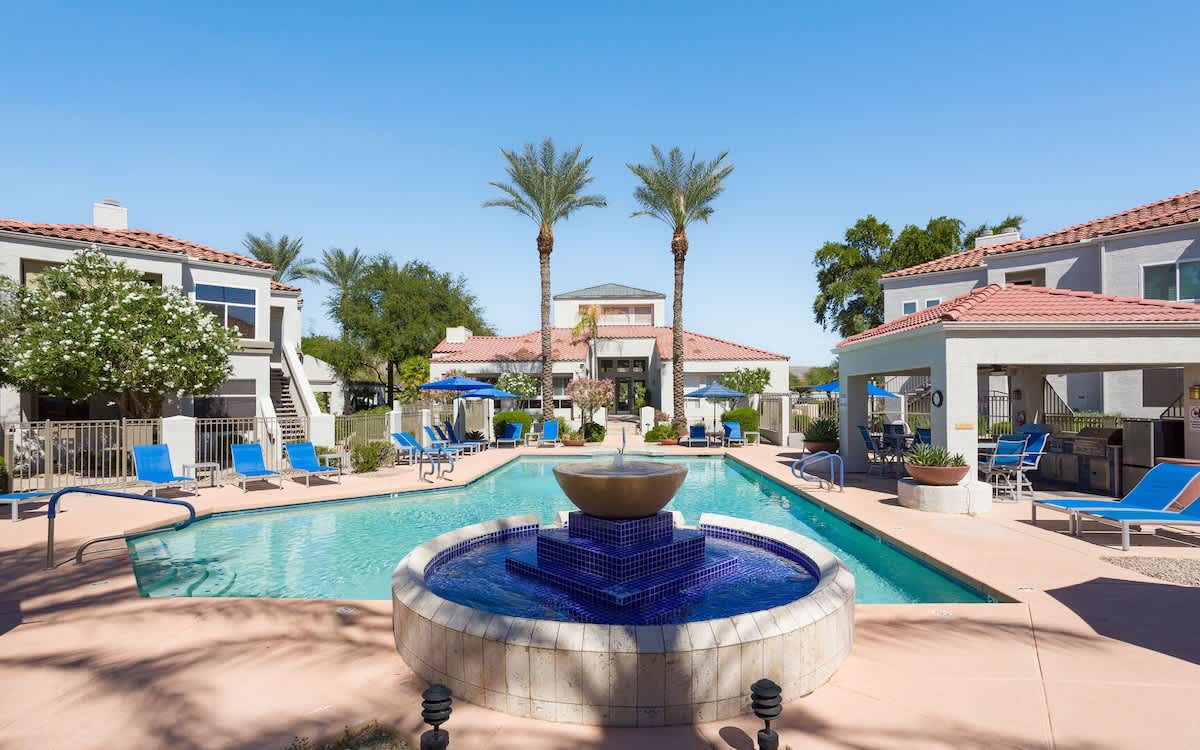 Enjoy the community pool area featuring a refreshing pool, relaxing spa, gas grills, outdoor dining tables with umbrellas, and plenty of sun loungers for the ultimate day of leisure.