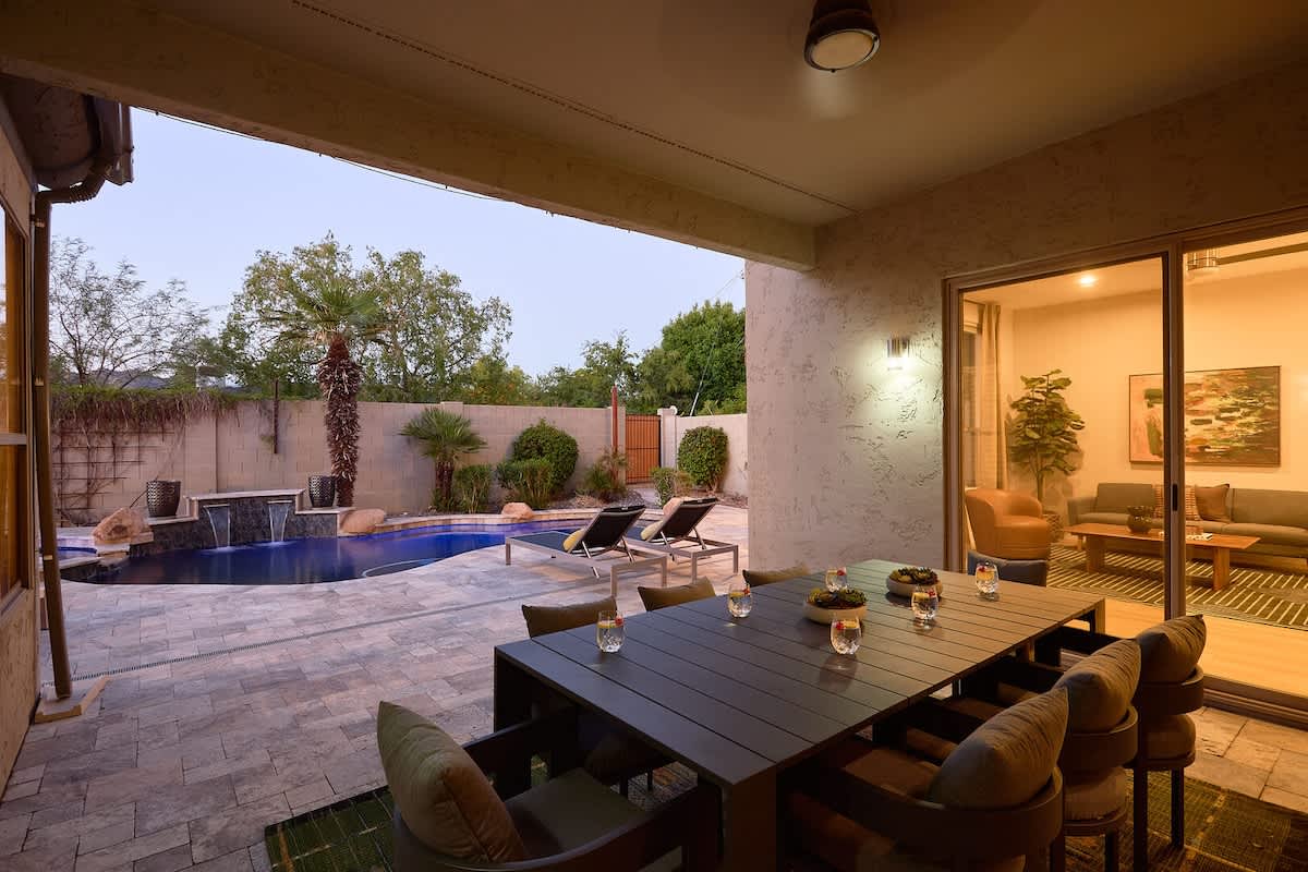 Backyard oasis featuring a covered patio w/ dining, sparkling pool with spa, plus a built-in grill and fireplace perfect for outdoor gatherings.
