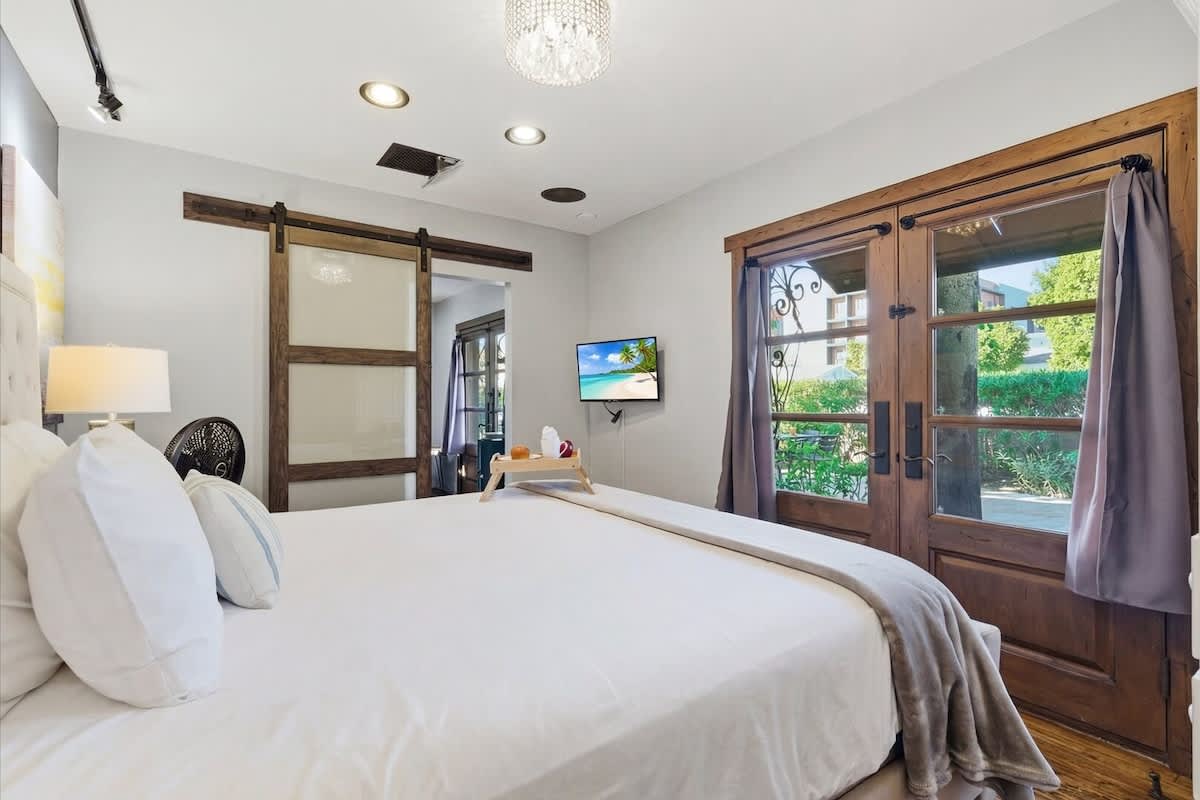 Primary Bedroom featuring a King bed, smart TV, wardrobe, and front yard access.