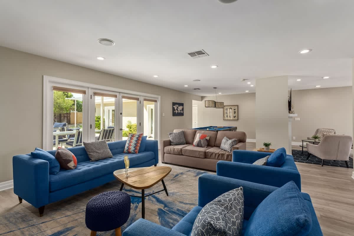 Spacious designer furnished living room featuring a Smart TV, Sound system, and a Pool table for entertainment.
