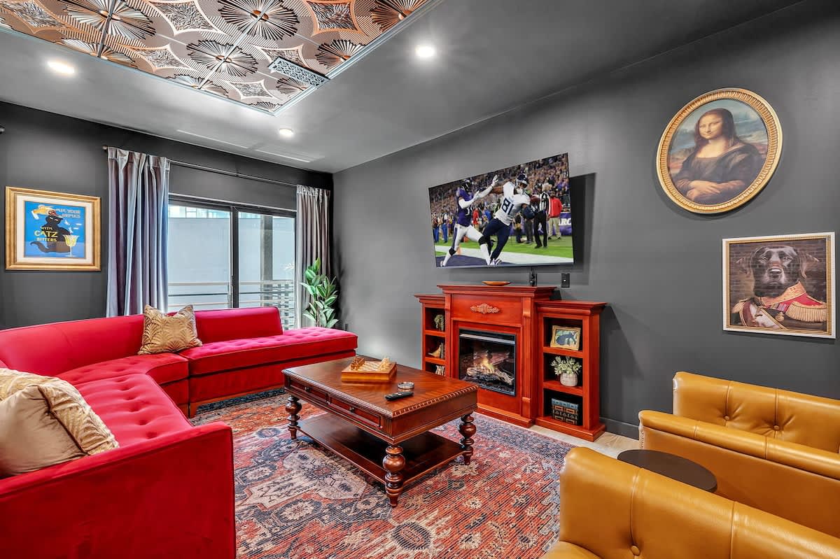 Open-floor living space featuring a smart flat-screen TV and designer furnishings. This inviting area effortlessly connects the dining space with the well-appointed kitchen.