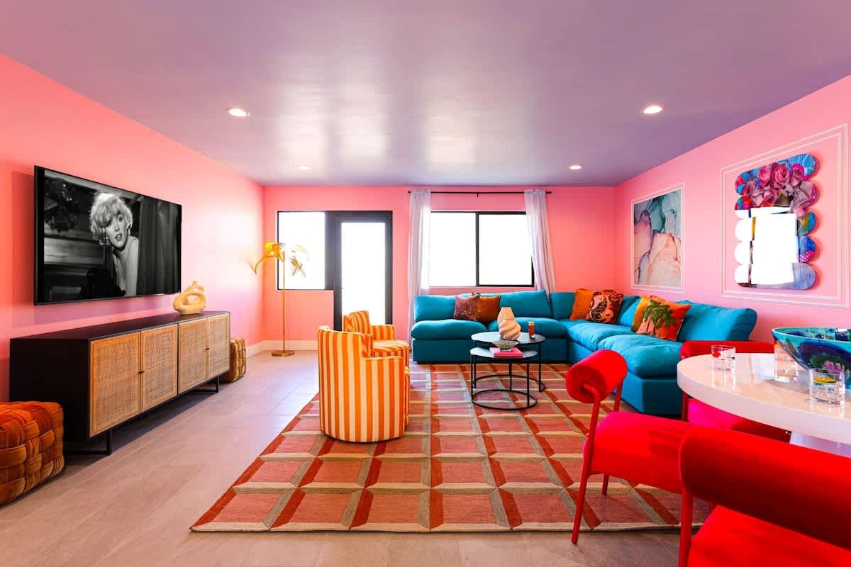 Home 1: Open living area featuring designer furnishings, a Smart TV, and a dining area with seating for 5 guests.