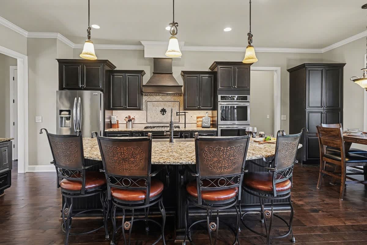 Fully equipped kitchen with stainless-steel appliances, a kitchen island with bar seating for 4, and an informal dining area with seating for 4.