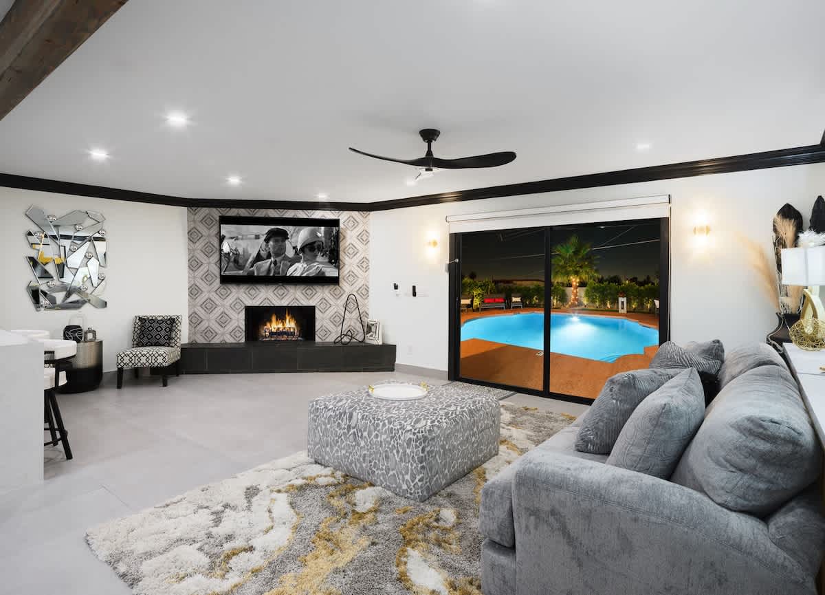Bright open formal living space features a smart flat-screen TV, fireplace, and designer furnishings.