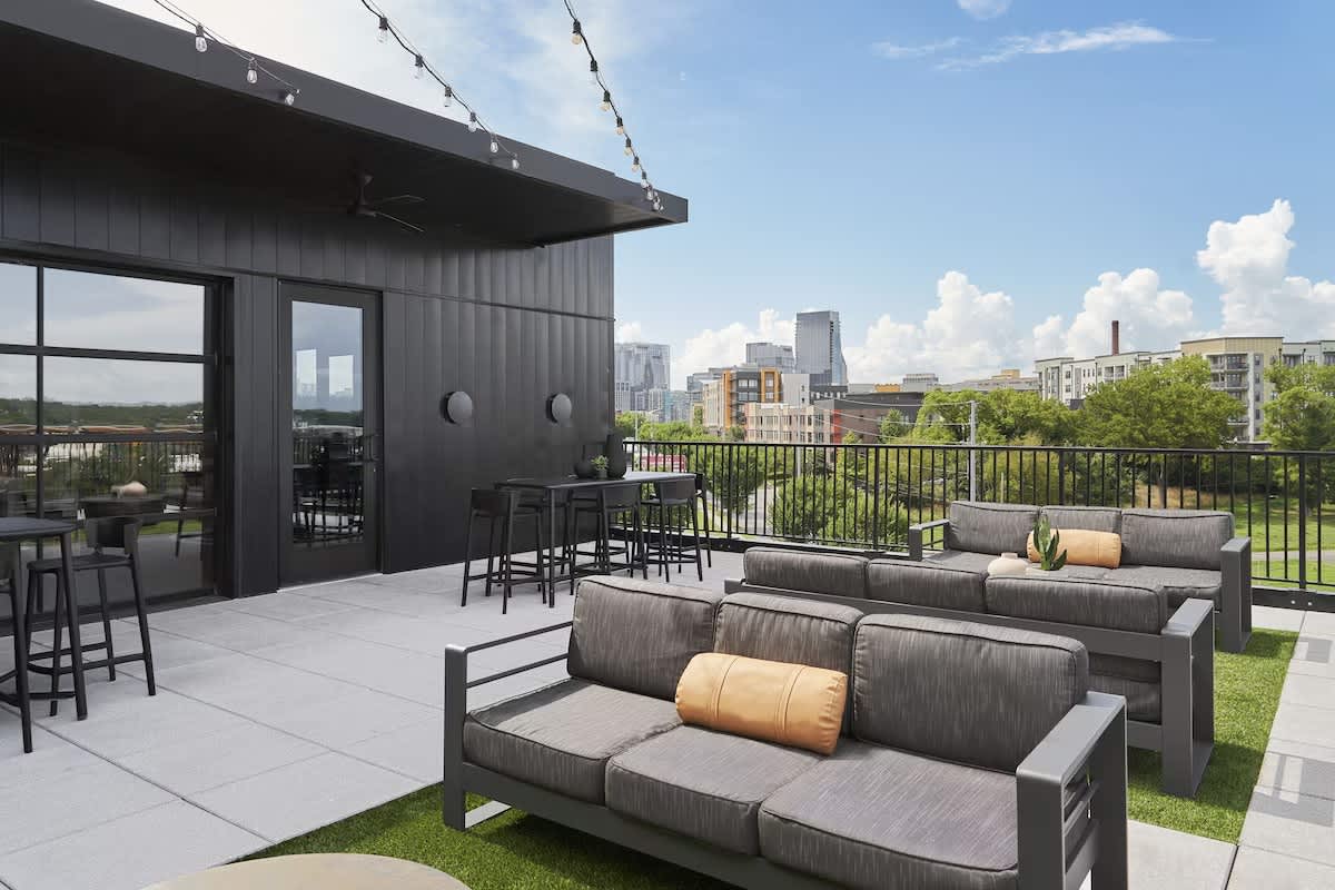 Communal Area: A stylish rooftop patio featuring outdoor lounge areas and an outdoor dining areas.
