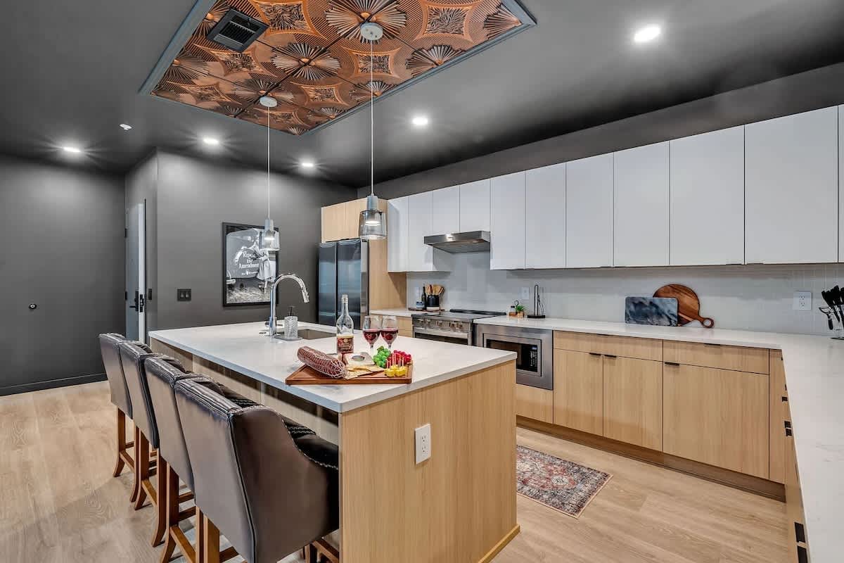 Unit 2: The fully equipped modern kitchen features culinary essentials, stainless steel appliances, and island bar seating.