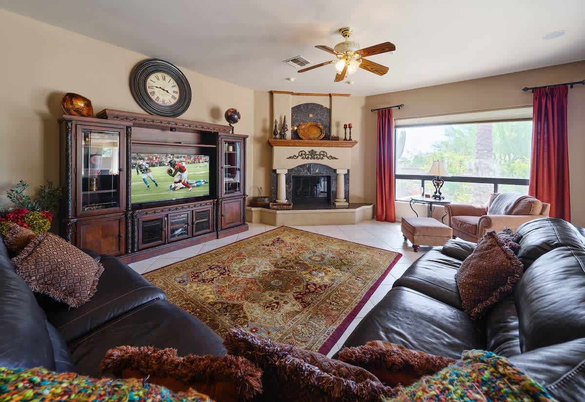 Spacious living area featuring a gas fireplace, large Smart TV, DVD Player, Board Games, and cozy furnishings.
