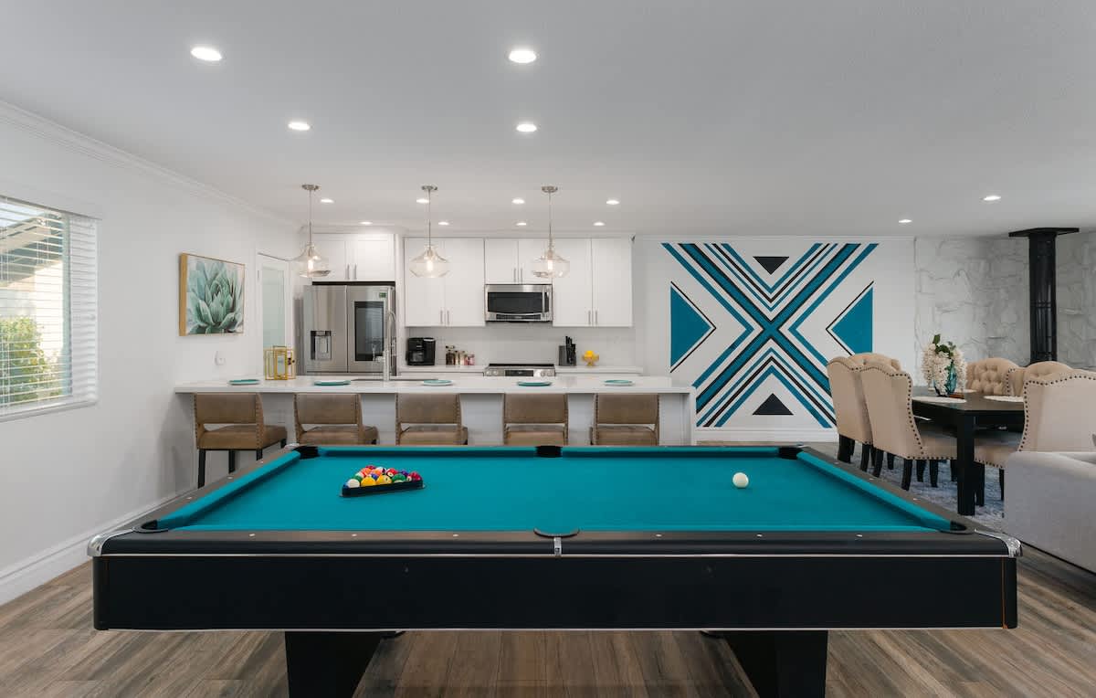 Living area featuring designer furnishings, a Smart TV, pool table, and access to the backyard.