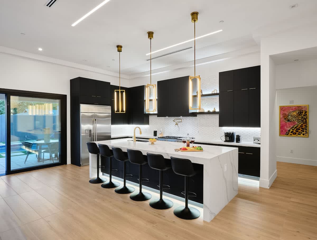 Fully equipped kitchen boasting high-end stainless-steel appliances, and a large island offering bar seating.