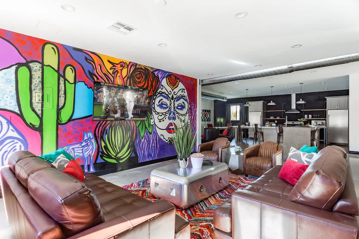 Open-floor living space featuring a Smart TV, designer furnishings, a beautiful mural on the wall, dining table, and a pool table.