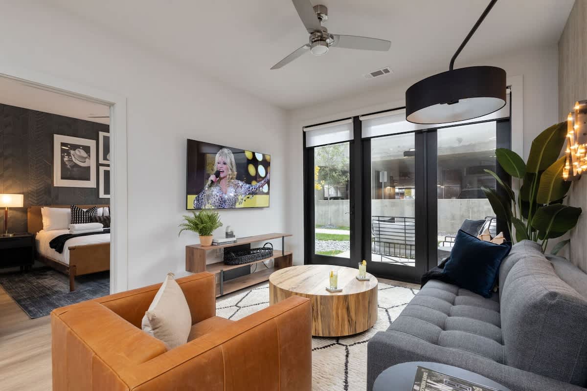 Bright living room with comfortable seating, smart TV, designer decor, and access to the private patio.