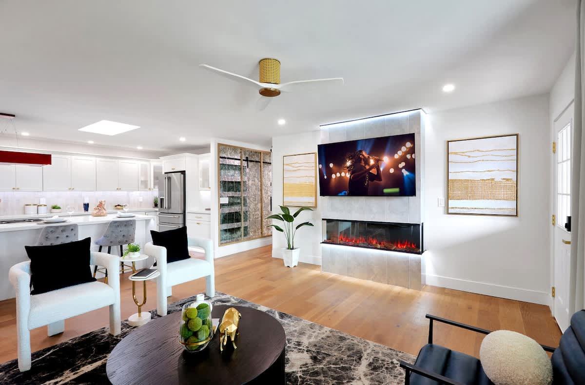 Open living area featuring a smart TV, plush furnishings, and a fireplace.