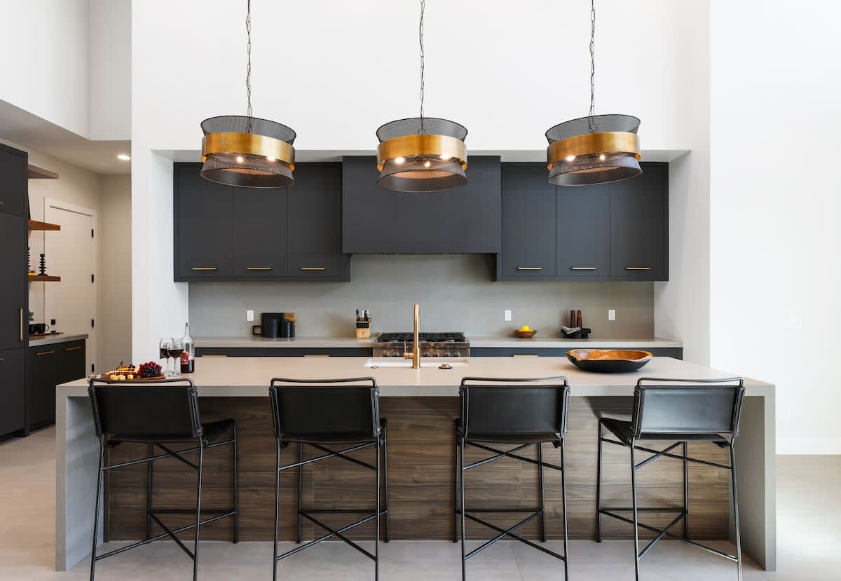 Unit 2: Fully equipped kitchen boasting high-end stainless steel appliances and a large island offering bar seating overlooking the formal dining area.