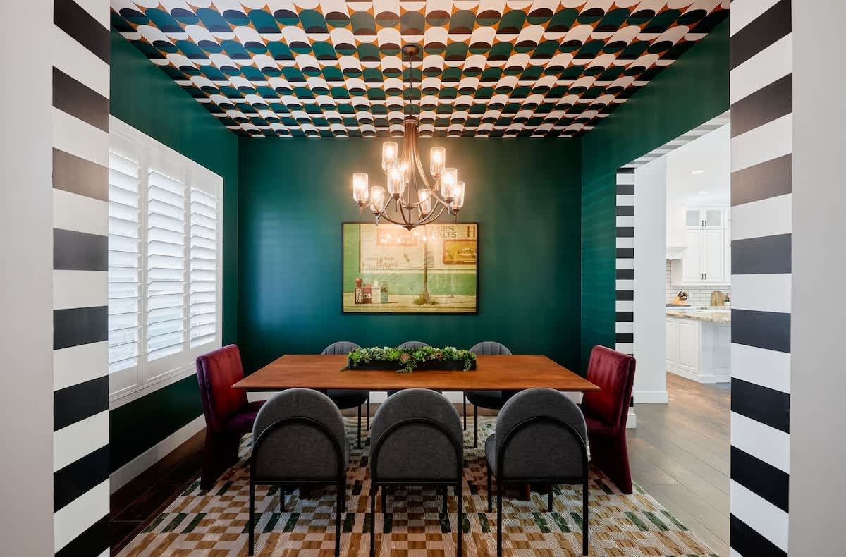 Formal dining room featuring a warm setting with a wooden table that seats 8, and a statement chandelier that elevates every meal.