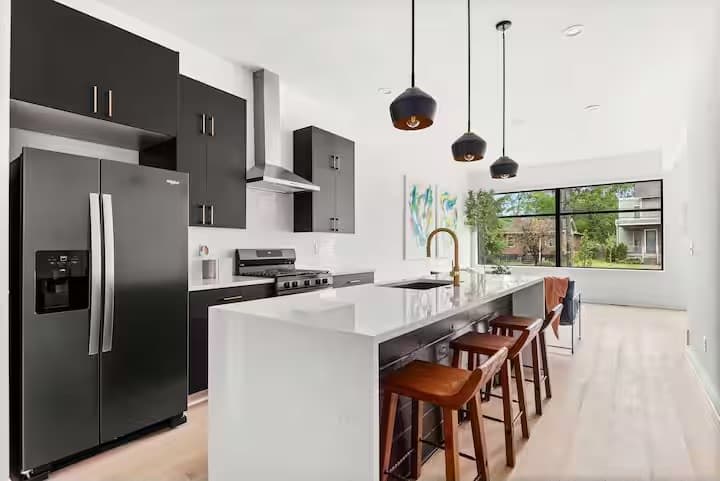 Modern kitchen with a spacious quartz island, bar seating, and updated appliances, designed for easy cooking and gathering. (1st Floor)