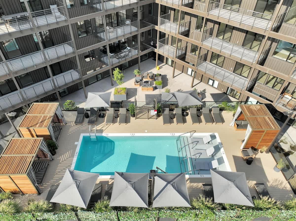 Communal Area: Sparkling blue pool with covered cabanas, sun loungers, and a wheelchair lift.