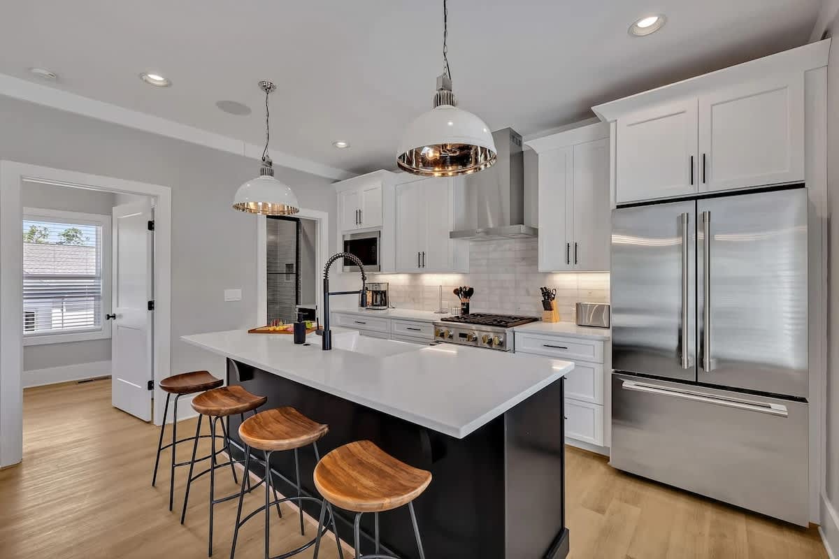 (Unit 1) 2nd Floor: Fully equipped kitchen, complete with all essential culinary tools, boasts stainless-steel appliances and a spacious island with ample counter space and bar seating.
