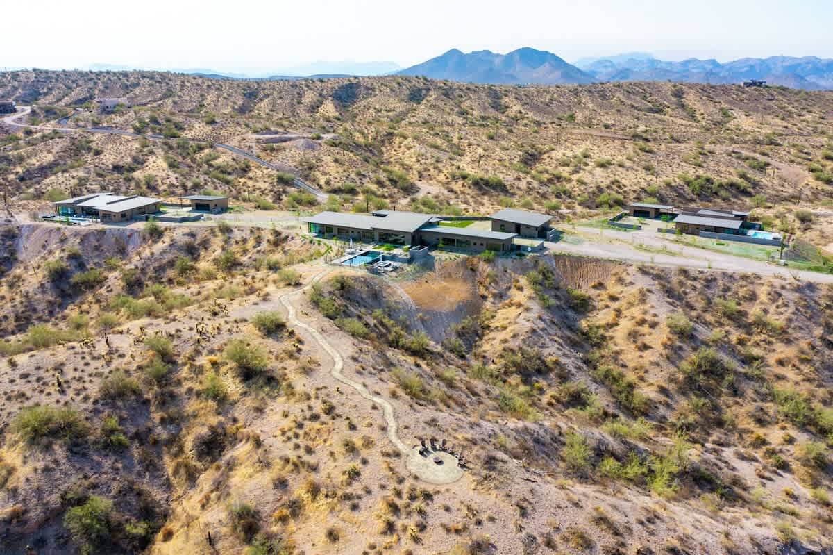 Estate 3: Stunning private oasis featuring a sparkling heated infinity pool and spa with sun loungers, a patio with a BBQ grill, multiple lounge areas, and fire pits surrounded by unparalleled desert 