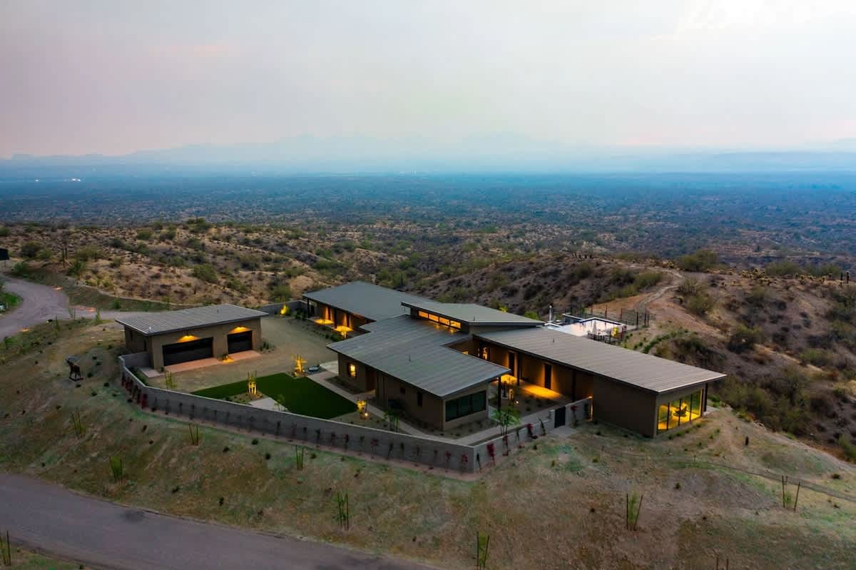 Estate 3: Stunning private oasis featuring a sparkling heated infinity pool and spa with sun loungers, a patio with a BBQ grill, multiple lounge areas, and fire pits surrounded by unparalleled desert 
