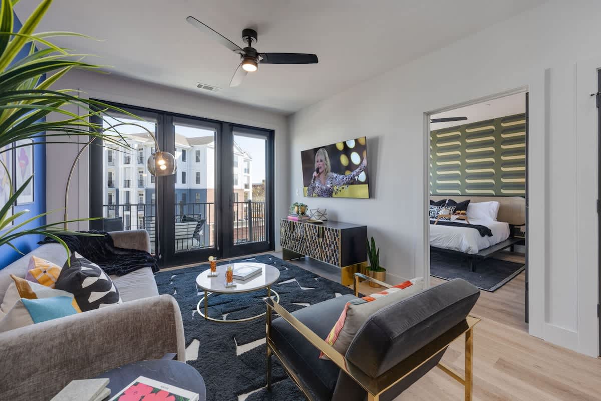 Bright open living space featuring a smart flat-screen TV and designer furnishings.