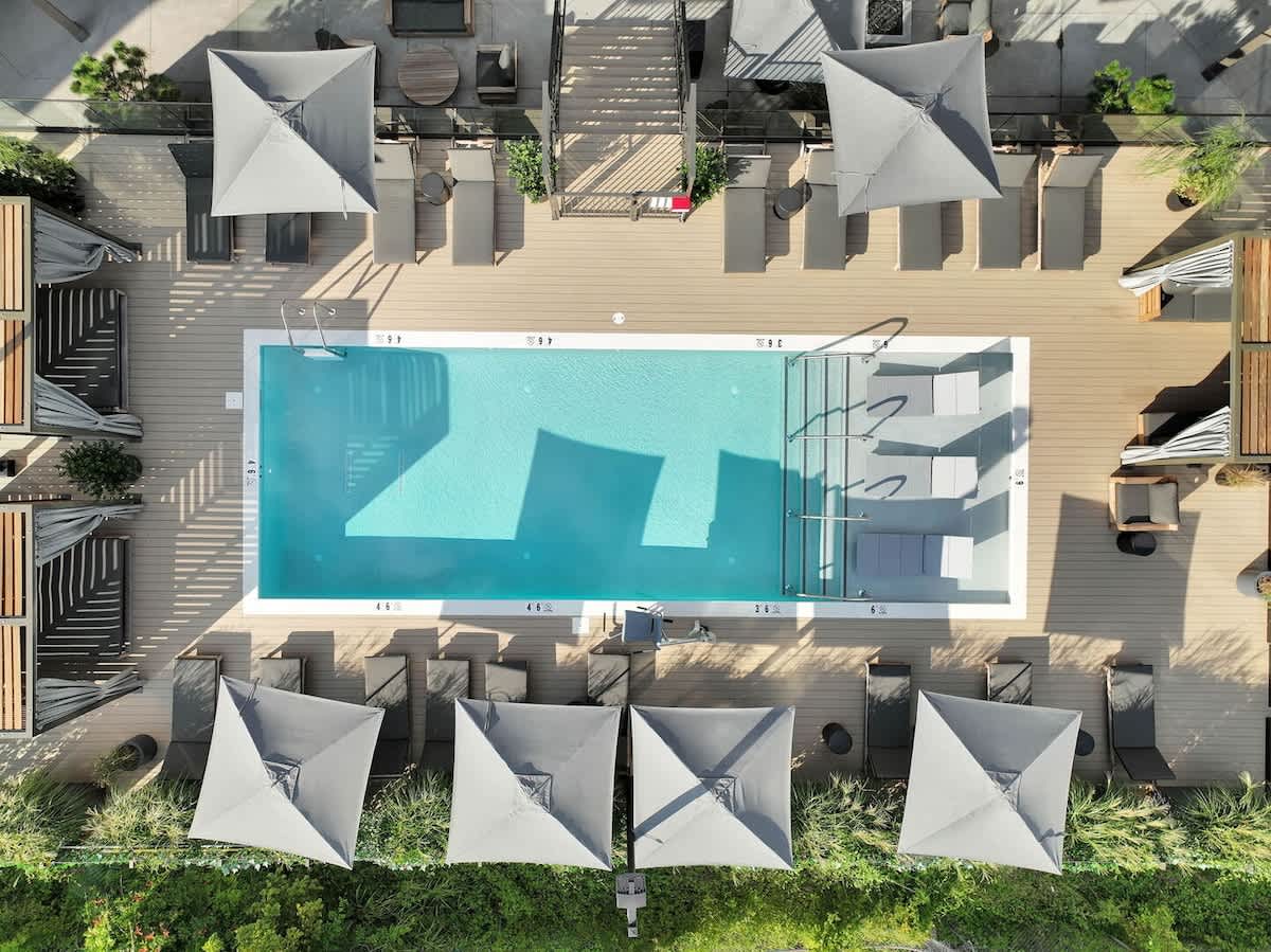 Communal Area: Sparkling blue pool with covered cabanas, sun loungers, and a wheelchair lift.