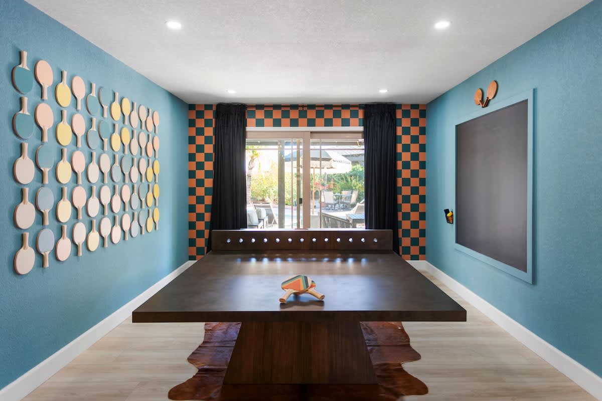 Game room with new ping pong table, chalkboard, unique designer ping-pong paddle wall, and private access to outdoor patio with pool.