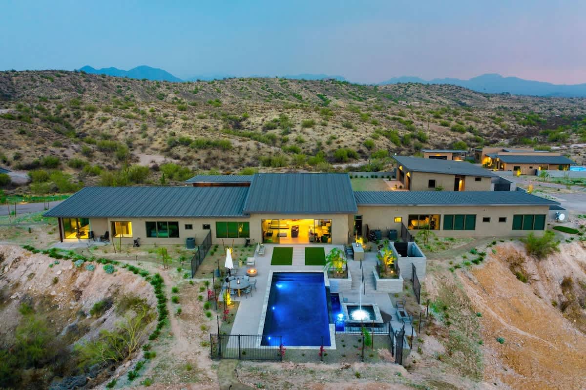 Estate 3: Stunning private oasis featuring a sparkling heated infinity pool and spa with sun loungers, a patio with a BBQ grill, multiple lounge areas, and fire pits surrounded by unparalleled desert 