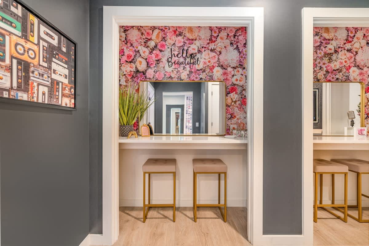 Dual get-ready stations with floral accents, large mirrors, and plenty of counter space—perfect for prepping in style.