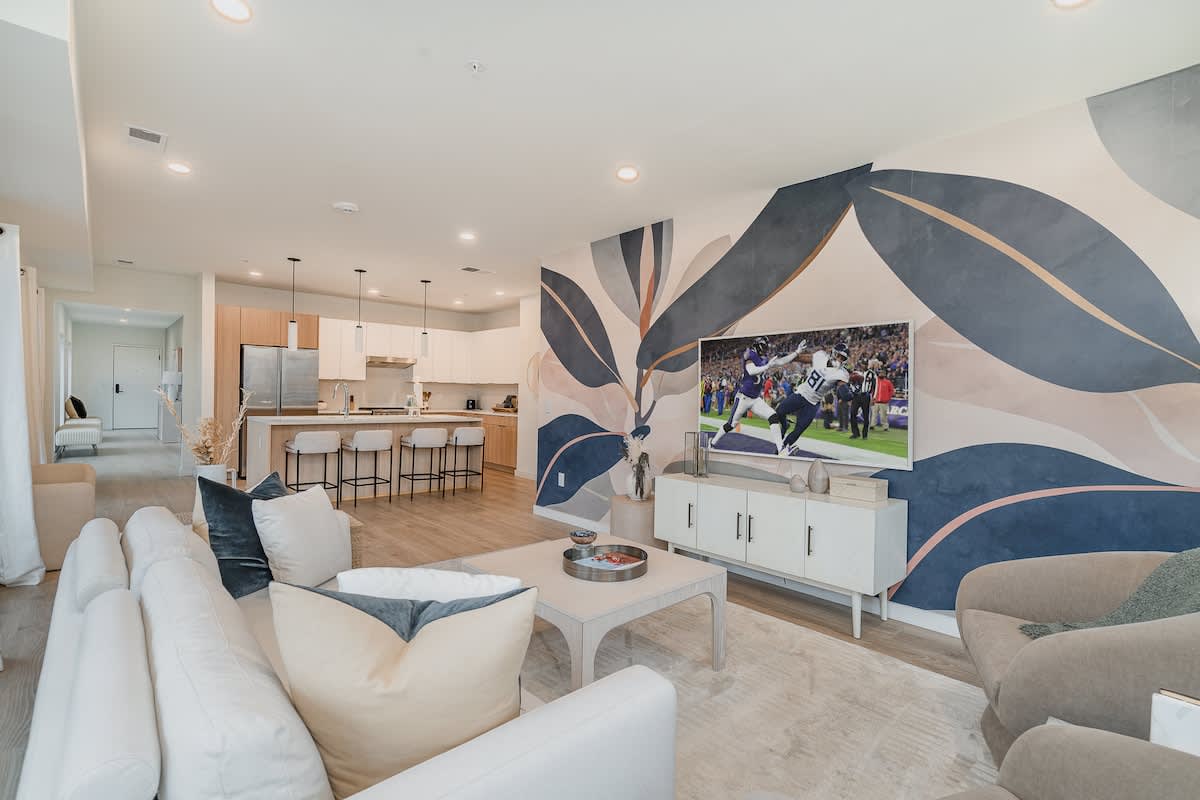 Bright open living space featuring Samsung Frame Smart TV, designer furnishings, and access to private patio.