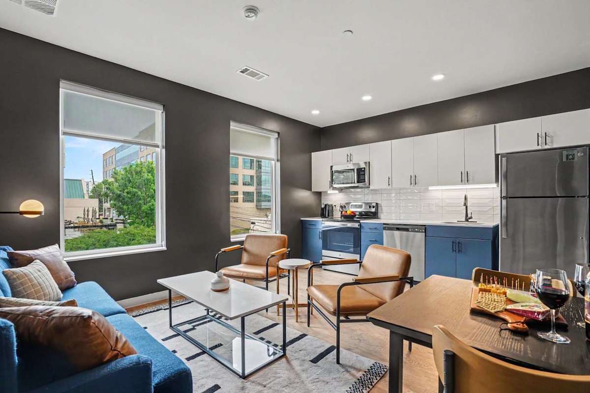Unit 1: Bright open floor living space featuring a smart flat-screen TV and designer furnishings. Connects to the dining area and kitchen. Sofa is also a sleeper sofa. 