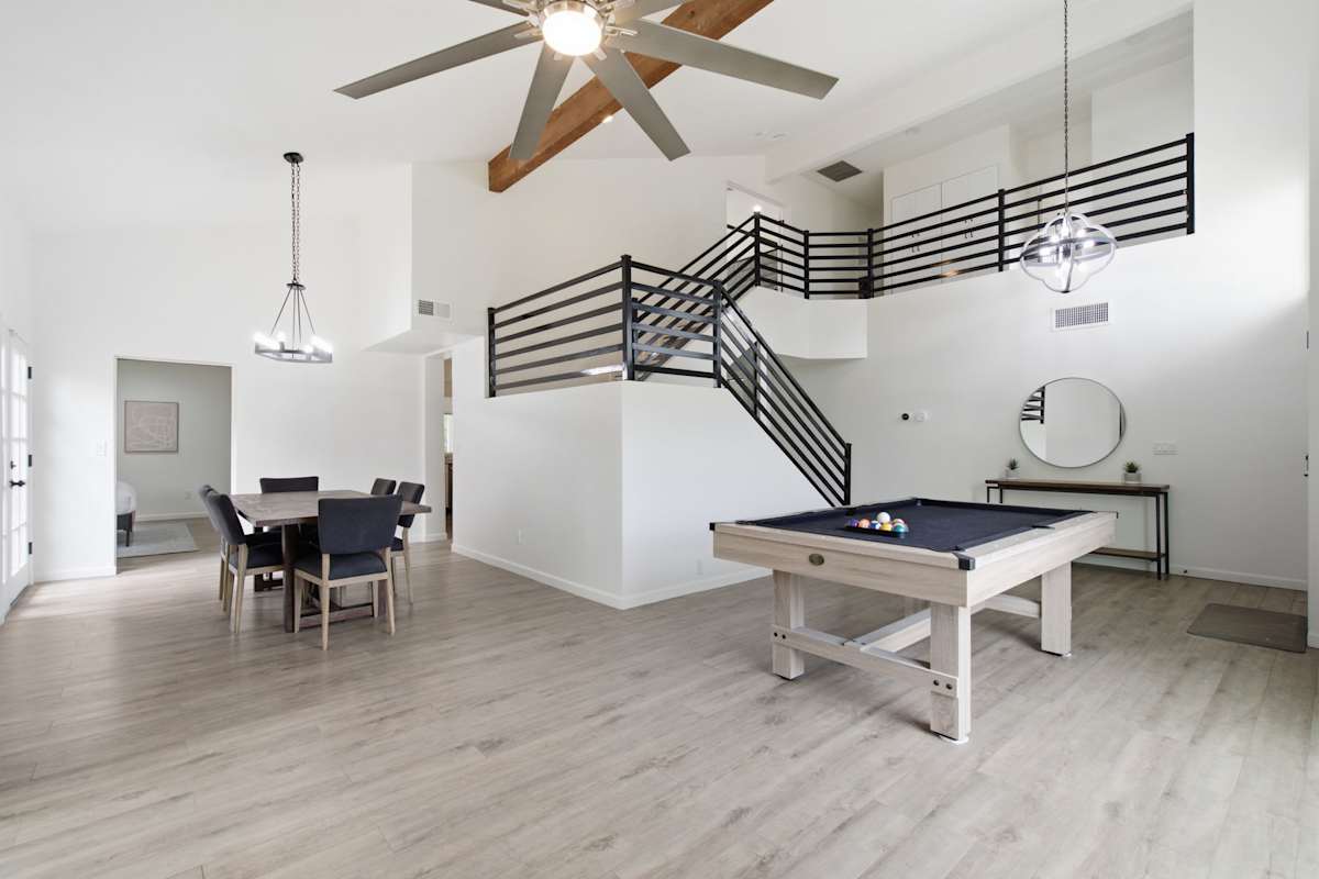 Pool table adjacent to a formal dining room with seating for 6 guests.