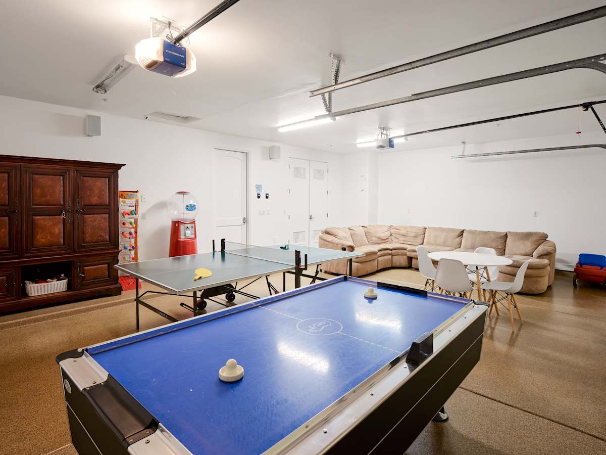 Garage converted into a full-on game room featuring a lounge area, ping pong, and air hockey.