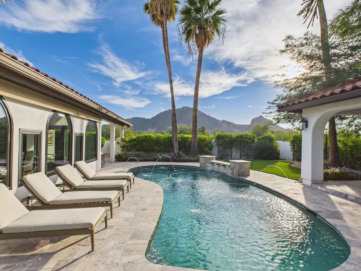 Outdoor oasis featuring a sparkling pool, lounge chairs, outdoor dining table, fire pit, and pergola with built-in BBQ grill. *Fireplace for display only.