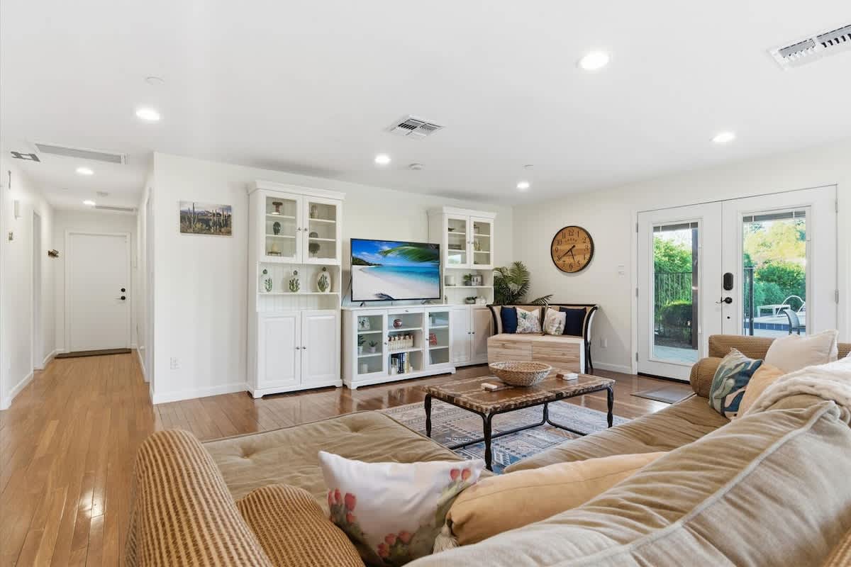 Main living area featuring cozy furnishings, a Smart TV, workstation with a office desk and chair, and access to the backyard.