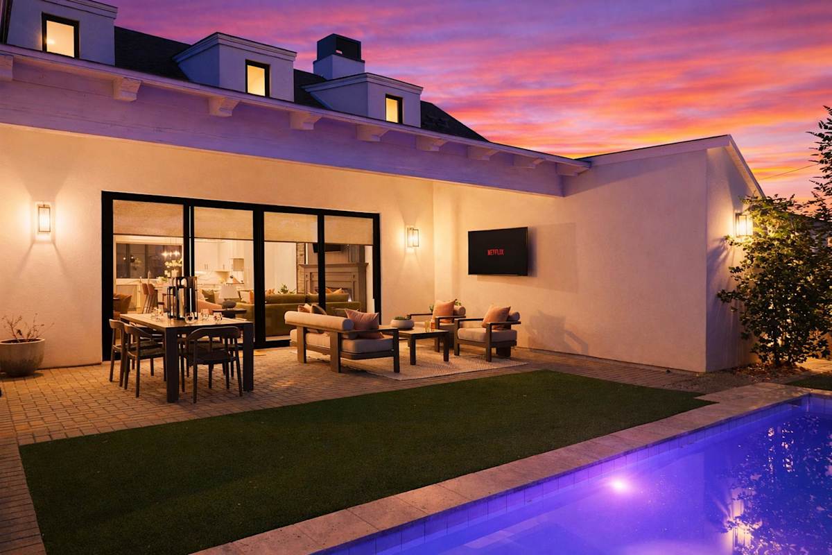 Private backyard with a sparkling pool and a covered patio with an outdoor dining area, outdoor seating, and a smart TV.