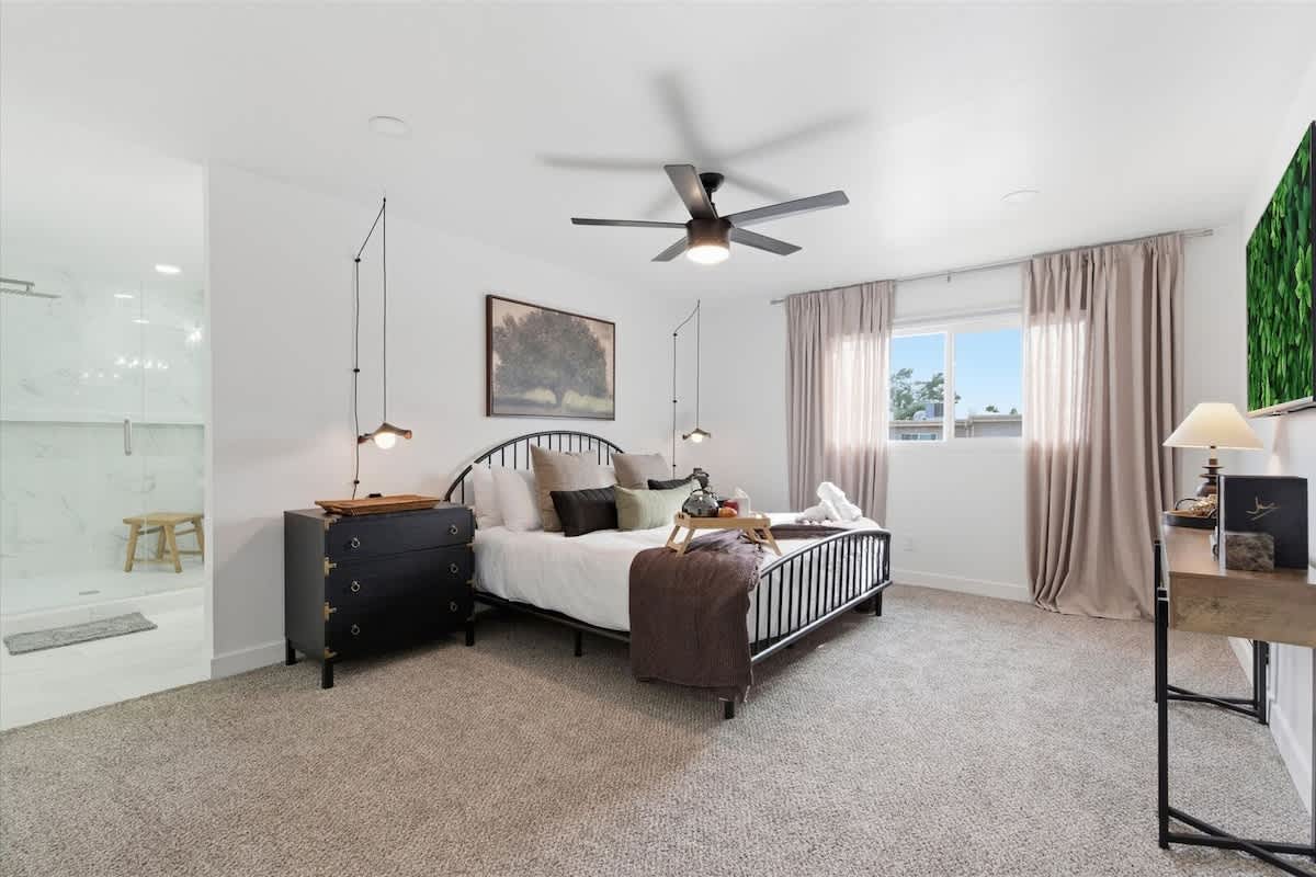 Primary Bedroom featuring a King bed, smart TV, and an en-suite bathroom with a walk-in closet.