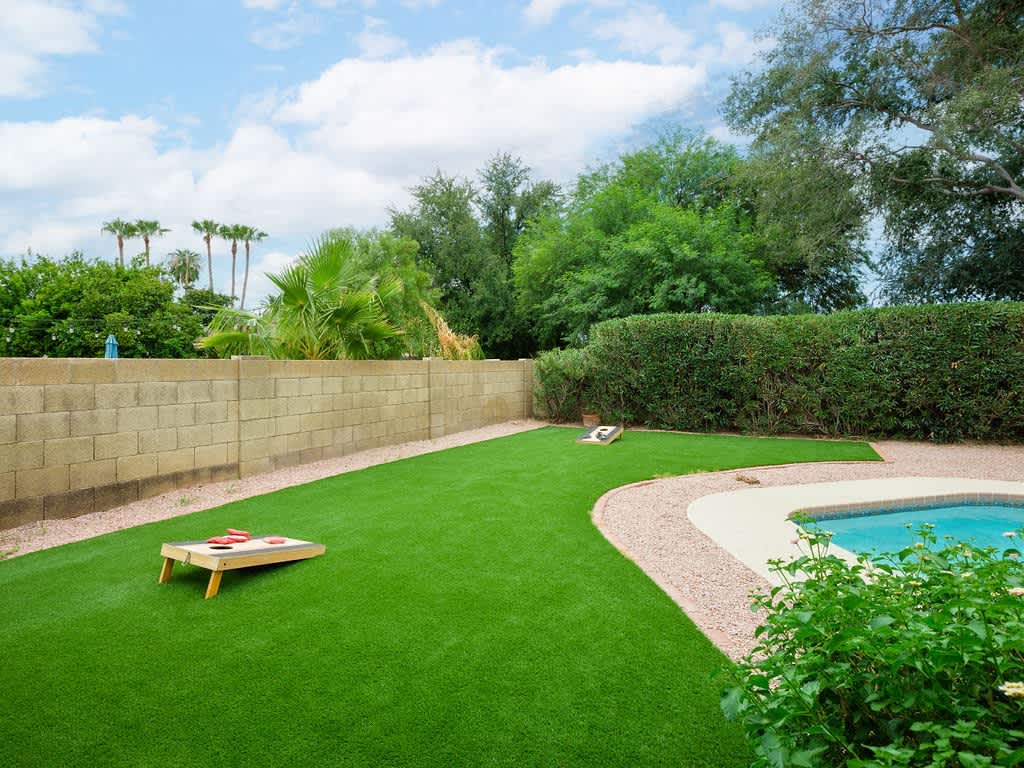 Spacious backyard with a private pool, sun loungers, BBQ, covered patio, outdoor dining, seating area, and corn hole!