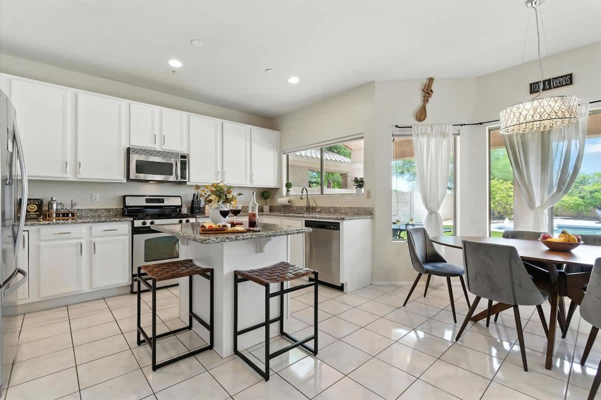 The fully equipped modern kitchen is stocked with all culinary essentials, stainless-steel appliances, and breakfast bar seating. (1st Floor)