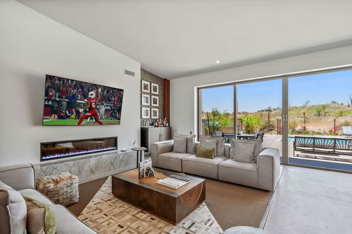 Spacious, light and bright living room featuring an electric fireplace, wet bar, Smart TV and designer furnishings.