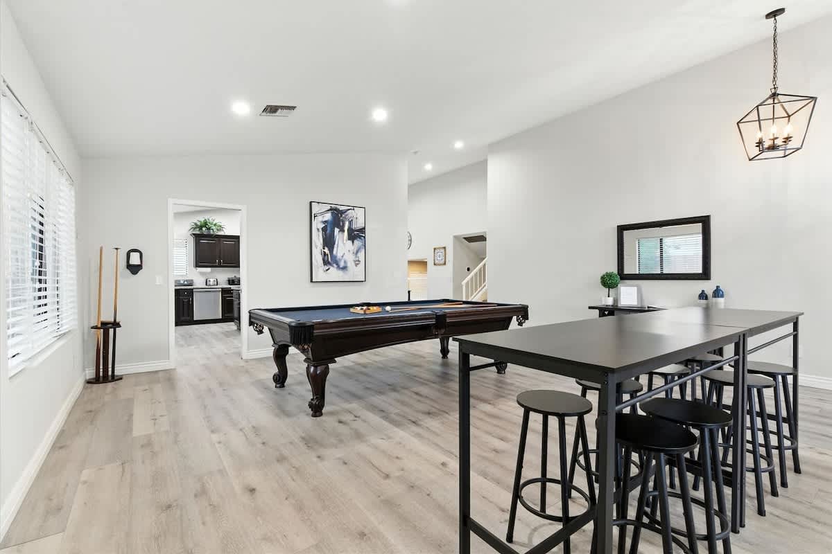This game and entertainment area features a pool table and a bar table with seating for eight, making it a fun spot for games and group hangouts.