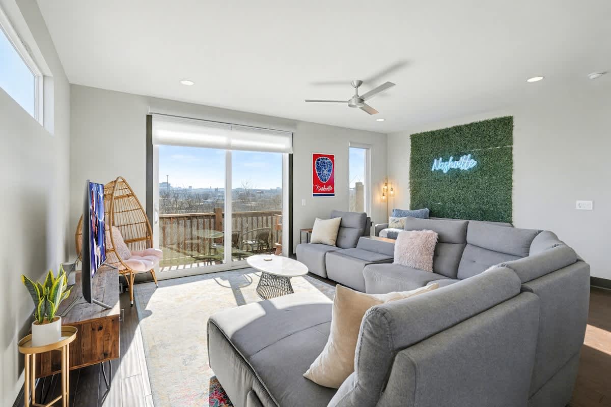 2nd Floor: Bright and open living area with cozy furnishings, a smart TV, Twin daybed with a Twin trundle, and a private balcony.